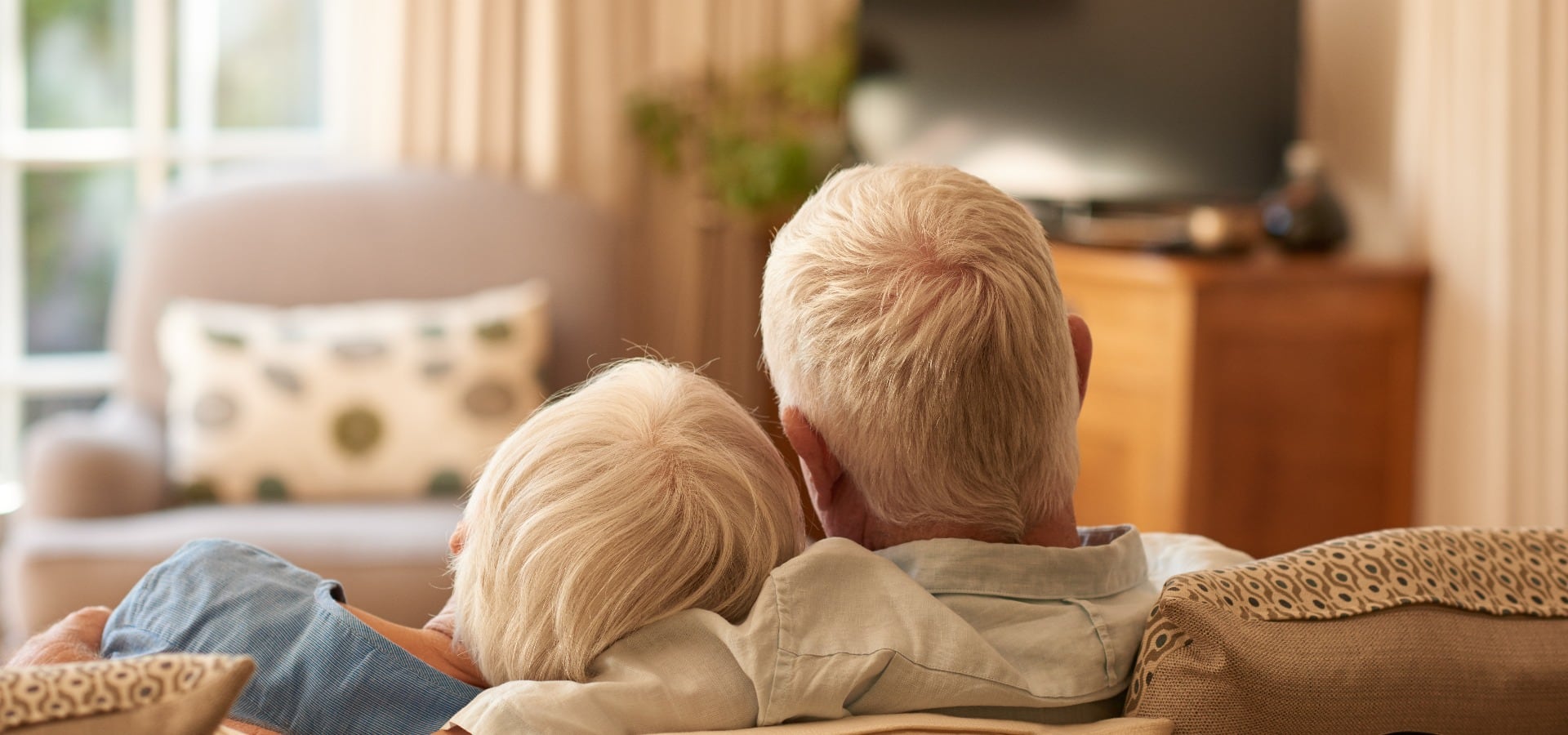 Zärtliches älteres Paar, das sich zu Hause auf dem Sofa entspannt